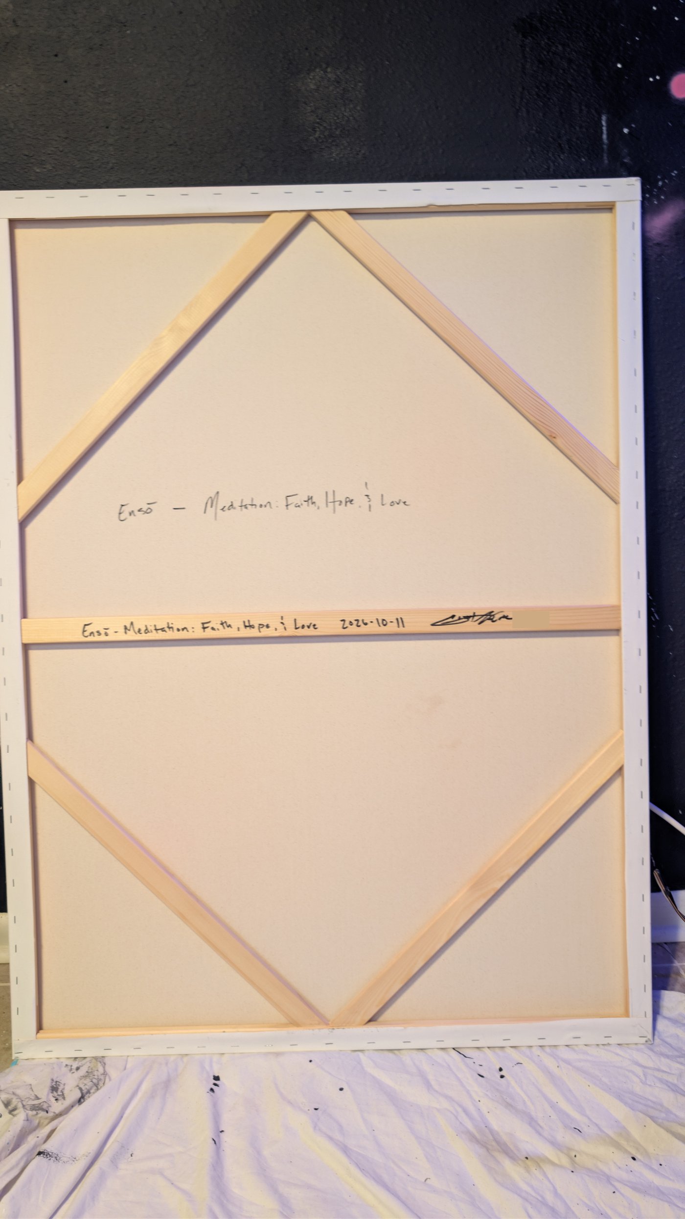 Back of the canvas showing the hand-lettered title, date and signature on the stretcher bar